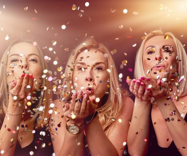 Picture of group of friends partying in a nightclub and toasting drinks